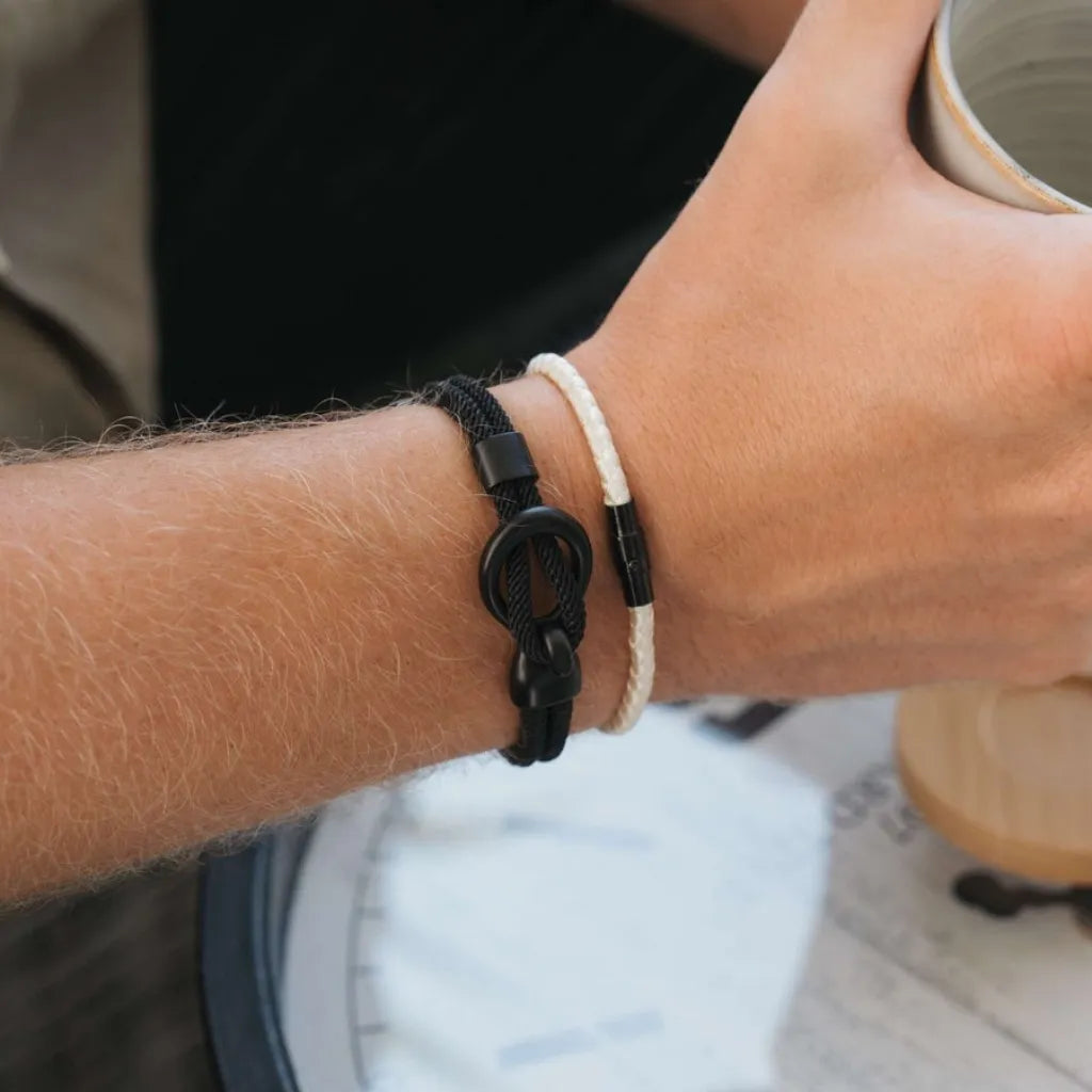 Vista lateral da pulseira Ravien preta com fecho em aço inox